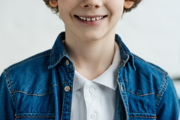 Wide smile by boy showing white teeth.