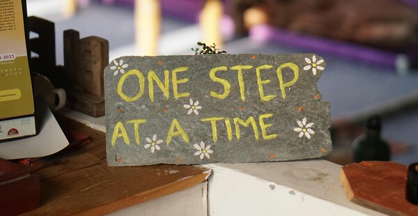 Picture of a sign with one step at a time writing