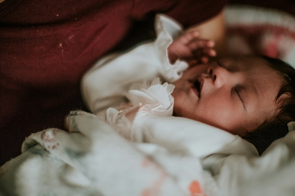 Baby in dress sleeping comfortably.