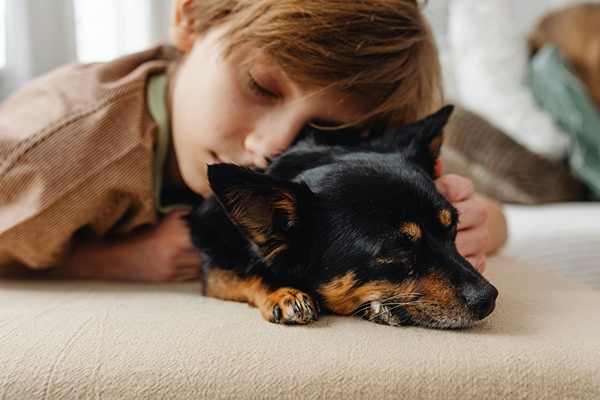 Boy on snuggling with his pet dog.