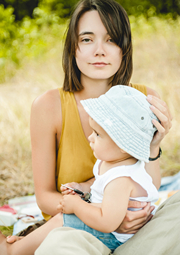 Mom holding baby outdoors in a park.