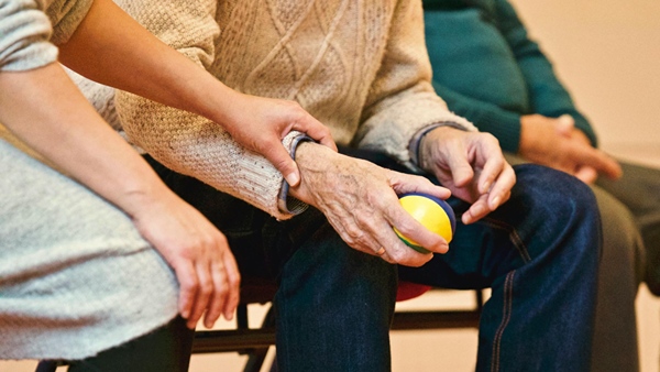 Nurse holding the hand of aged man