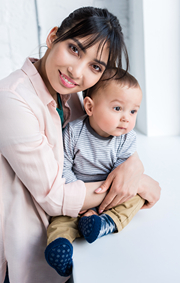 Mother holding her young child and smiling.