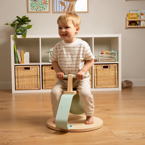 Boy happily playing on toddler bouncer toy.