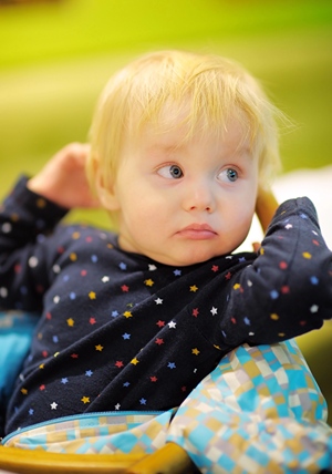 Toddler sitting down and looking backward.