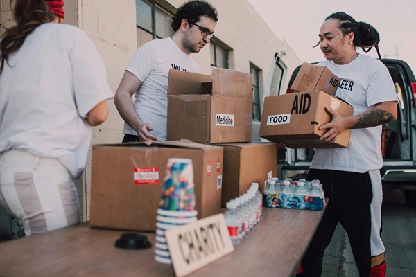 Group of volunteers sorting goods at warehouse.