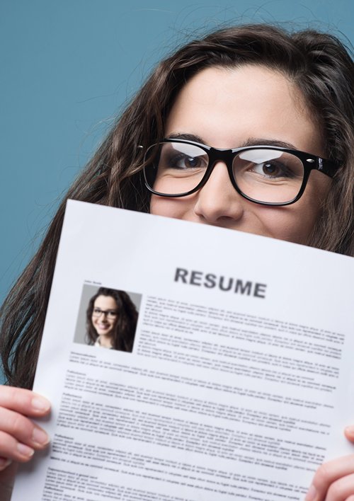 Woman hold up her resume with only her eyes showing.