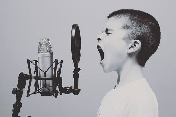 A child shouting into a microphone. 