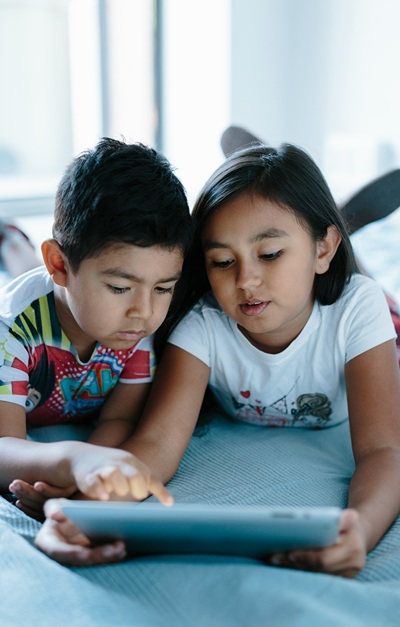 Boy and Girl playing game together on tablet.