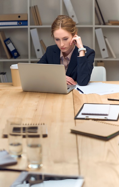 Professional woman at office desk working on laptop