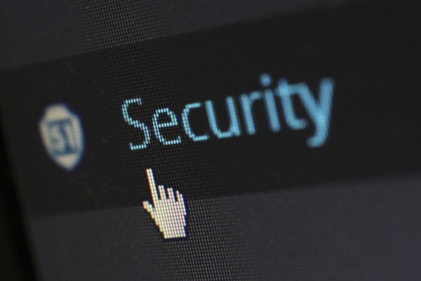 The word security on computer screen with mouse icon of a hand over top.