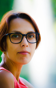 Women turning her head with calm confident look with light in background.