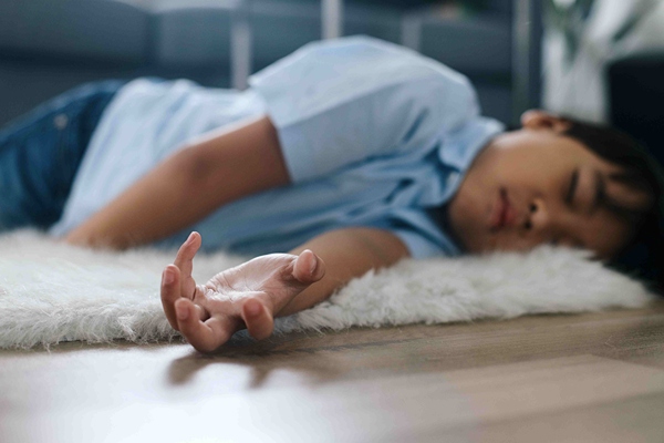 Boy passed out on floor as if having a seizure.