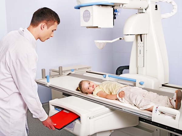 Doctor with Child on X-ray Machine.