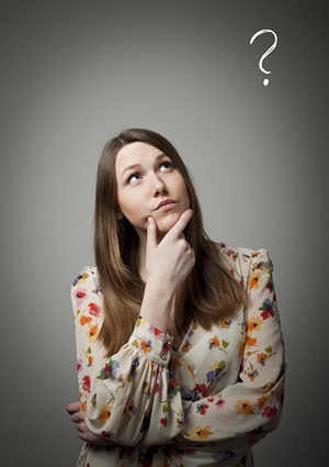 A teacher standing with hand on chin looking up at a question mark.