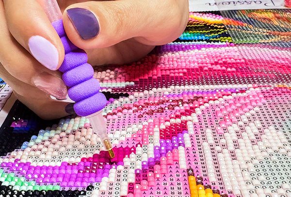 Closeup of hand doing diamond painting.