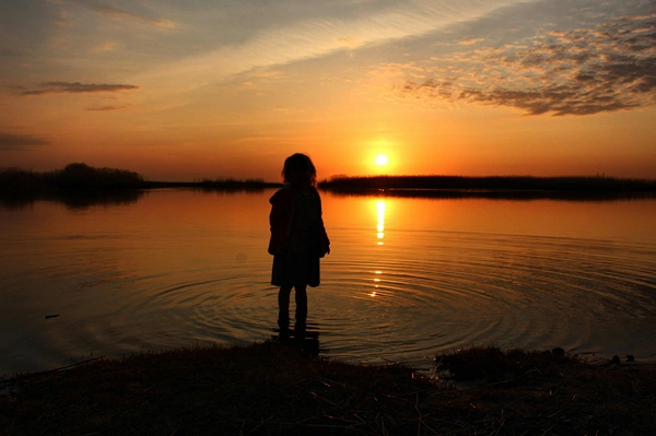 Sunset silhouette of a little girl.