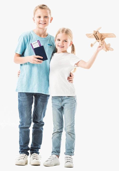 Boy holding passport in his hand while holds up a wooden toy airplane.