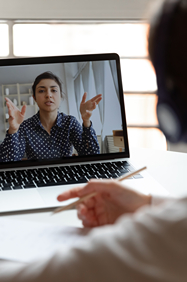 Woman seen on laptop screen teaching student at his desk at home.