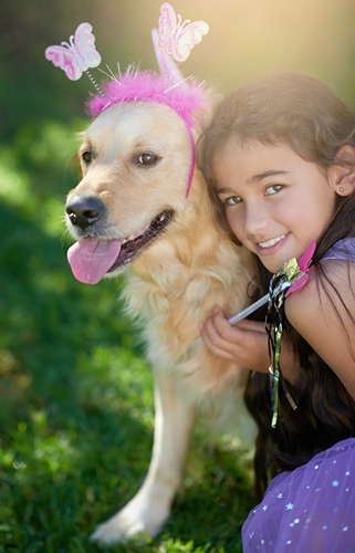 Girl playing dressup with the family dog.