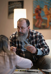 Older man playing cards with child.