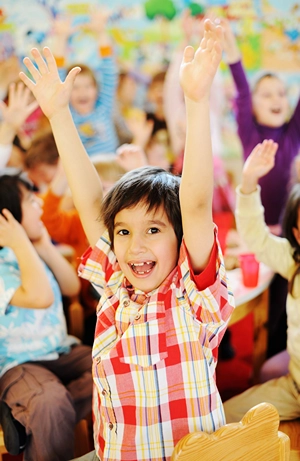 Group of kids raising their hands and having at a fun.