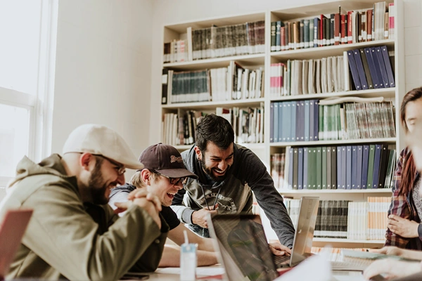 Group of college students working on project around table.