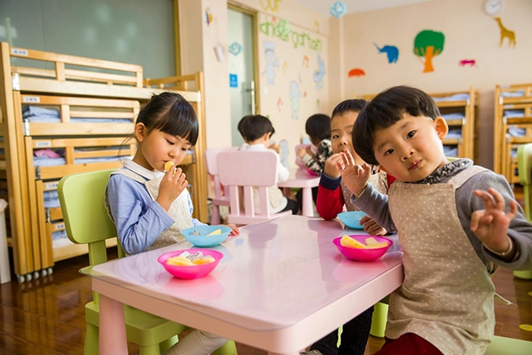 Group of pre-schoolers eating lunch together.