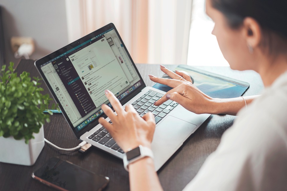 Young woman intently typing on her laptop.