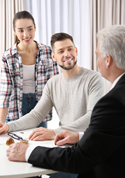 Young couple is consutling with a lawyer in his office.