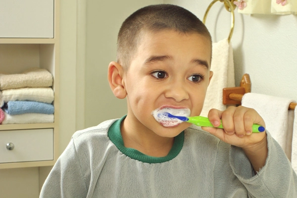 Determined boy brushing his teeth.