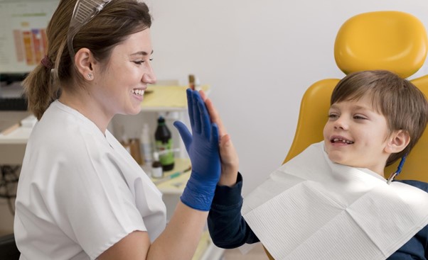 Female dentist smiling and talking to boy before his dental work.