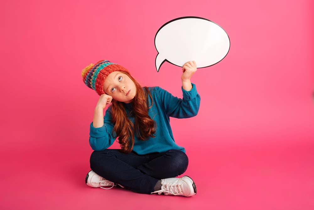 Girl holding up an empty speech cloud over her heard. 