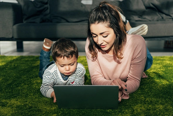 Mom teaching her young boy how to use the internet.