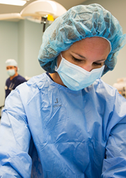 A nurse with mask and head cap.