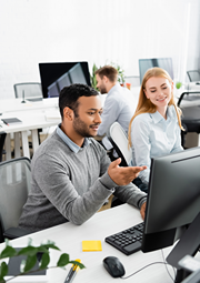 A man and women are working together on a computer.