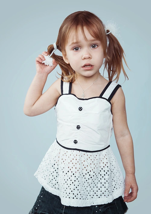 Toddler girl with a puzzled expression.