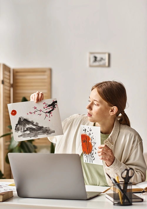 Female student holding up sketches she drew.