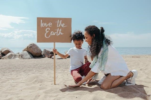 Mom and son putting up a "love the earth" sign.