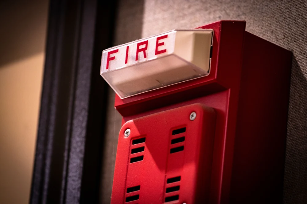 A closeup of a school fire bell on wall.