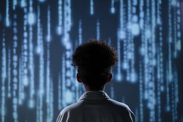 View from behind a boy looking at wall of lights.