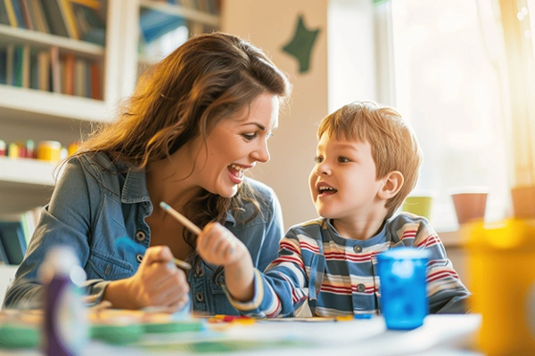 Woman and boy with pencils in hand working at a table.