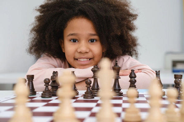 Smiling African American girl playing chess.