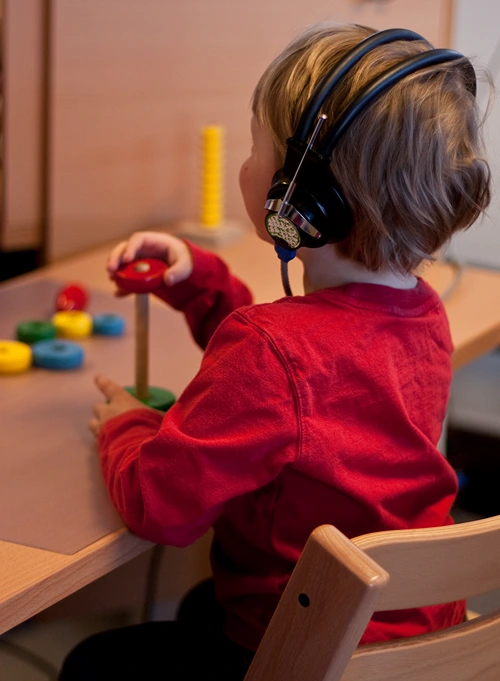 A little boy with headphones on taking a hearing test.