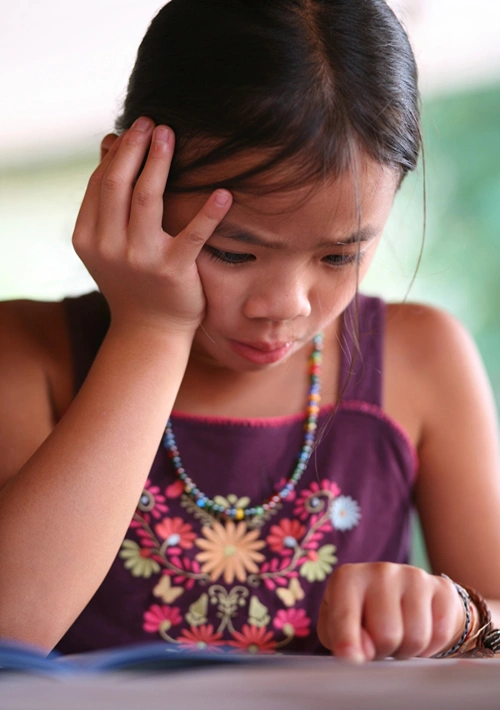 A young girl is struggling to read.