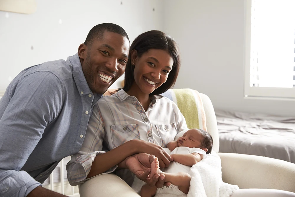 New African American parents in hospital holding their new baby.