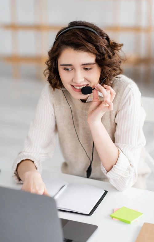 Online tutor with headset teaching on laptop.