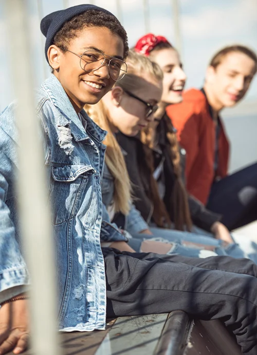 Four teens hanging around outside at a park.