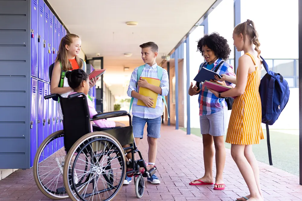 A child in a wheelchair talking in a circle of friends.