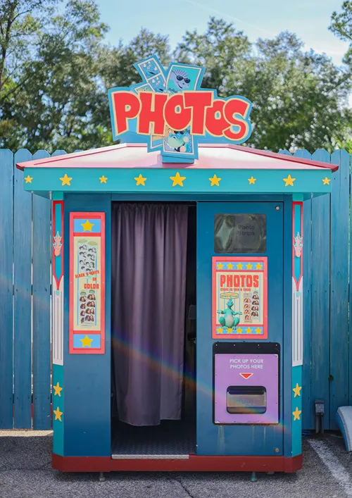 A traditional photo booth outside in the summer.